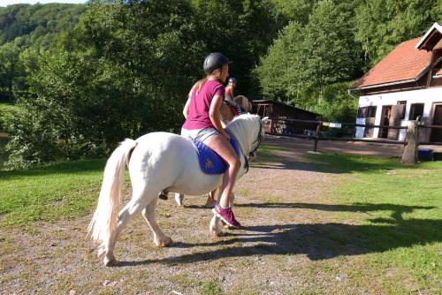 a woman riding on a white horse at Green Valley Park in Stárkov