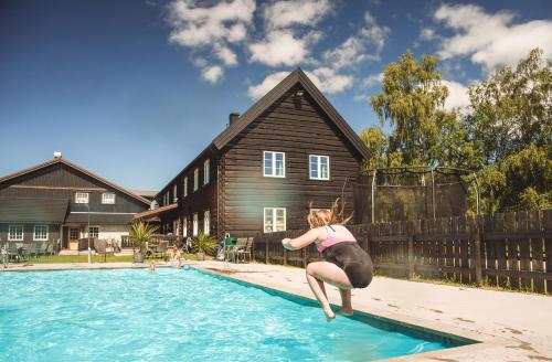 a woman is jumping into a swimming pool at Toftemo Turiststasjon in Dovre