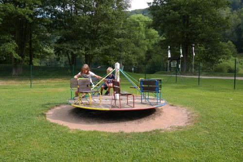 two girls playing on a merry go round in a park at Green Valley Park in Stárkov