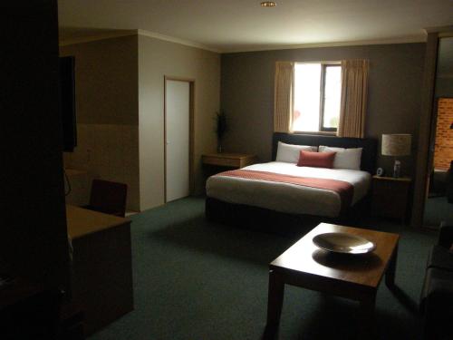 a hotel room with a bed and a window at Quality Inn Colonial in Bendigo