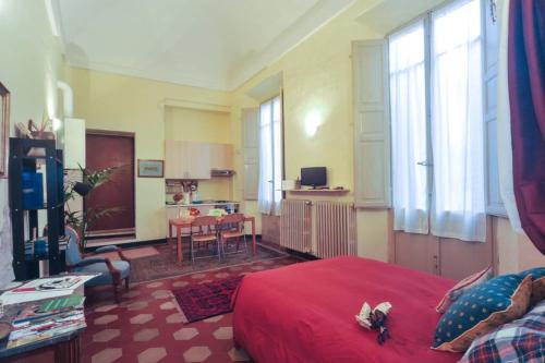 una camera con letto rosso e un soggiorno di Cozy apartment in Palazzo Malaspina a Piacenza
