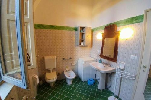 a bathroom with a sink and a toilet and a mirror at Cozy apartment in Palazzo Malaspina in Piacenza