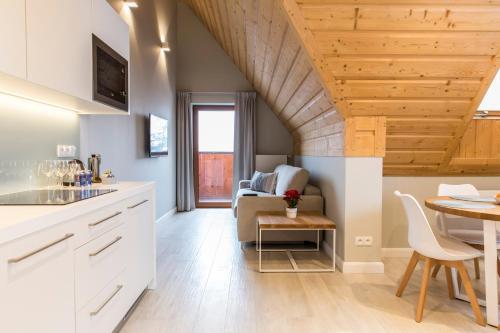 a kitchen and dining room with a table and a dining room at Royal Hill Residence in Zakopane