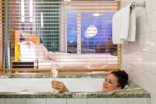 a woman in a bathtub holding a glass of champagne at Hotel Rival in Stockholm
