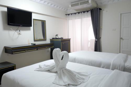 a hotel room with two beds with a swan decoration at Romance Hotel Sukhumvit 97 in Bangkok