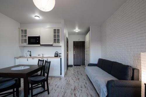 Una sala de estar con un sofá y una mesa y una cocina. en Kamienna Wisła, Sun & Snow, en Wisła