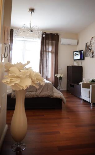 a living room with a bed and a vase with a flower at Pompeii Ruins De Charme B&B in Pompei