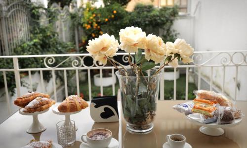 a table with a vase of flowers and cookies at Pompeii Ruins De Charme B&B in Pompei