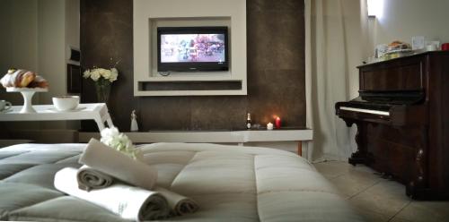 a bedroom with a bed with a television and a piano at Pompeii Ruins De Charme B&B in Pompei