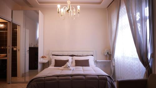 a bedroom with a large bed with a chandelier at Pompeii Ruins De Charme B&B in Pompei