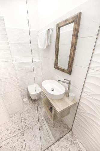 a white bathroom with a sink and a toilet at OH Apartments & Rooms in Ljubljana