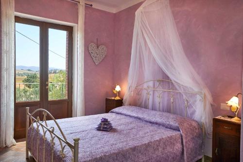 um quarto com uma cama de dossel e uma janela em Agriturismo MonteCrespini em Saturnia