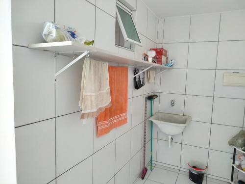 a bathroom with white tiled walls and a sink at Carlos Roberto Da Costa in Nossa Senhora do Livramento