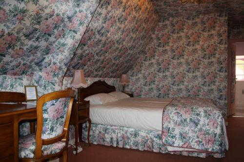 a bedroom with a bed and floral wallpaper at Château Des Bondons EI in La Ferté-sous-Jouarre