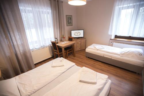 a bedroom with two beds and a table and a desk at Dom Nad Wodospadem in Miedzygorze