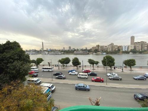 a parking lot with cars parked next to a river at Brassbell l Downtown l Maspero in Cairo