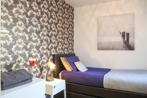 Un dormitorio con una cama y una mesa con una lámpara. en Perfect Central City Location - Parking - 3 Beds - 2 Bedrooms, en Belfast