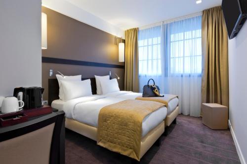 a hotel room with two beds and a television at Simon's Boutique Hôtel in Paris