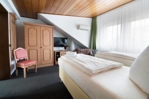 a hotel room with two beds and a chair at Hotel Zum Eisenhammer in Oberhausen