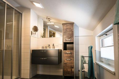 een badkamer met een wastafel en een spiegel bij Appartement Zill in Tux