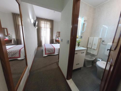 La salle de bains est pourvue d'un lavabo, de toilettes et d'un miroir. dans l'établissement Lusitana Hotel, à Porto