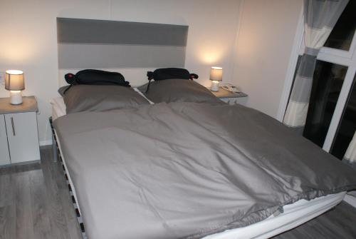 1 cama en una habitación con 2 lámparas en 2 mesas en Chalet Seeliebe en Lathum