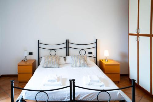 ノヴァーラにあるV12 Apartments - Tadini 14のベッドルーム1室(白い大型ベッド1台、ナイトスタンド2台付)