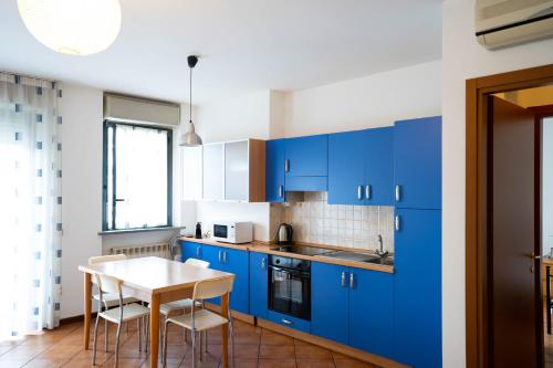 ノヴァーラにあるV12 Apartments - Tadini 14の青いキャビネットとテーブル付きのキッチン