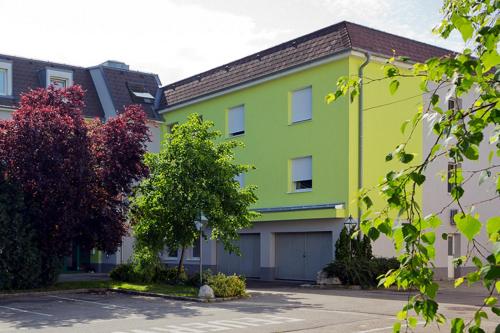 ein gelbes und grünes Gebäude mit einer Garage in der Unterkunft Motel Baden in Baden