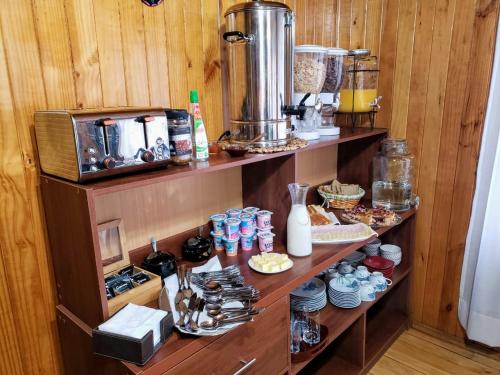 una cocina con dos estanterías con comida. en Hospedaje Amapola en Castro