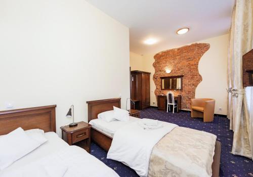 a hotel room with two beds and a brick wall at Hotel Marczewski in Bielsko-Biała