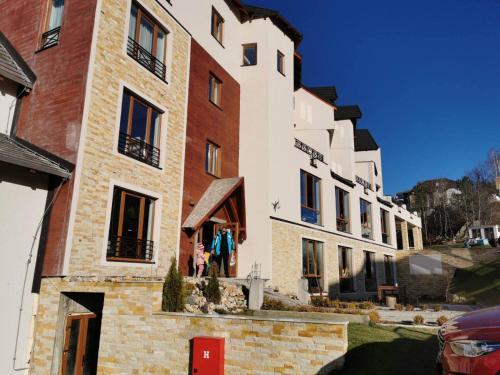 a group of buildings with a person standing outside of them at Apartmani Džanković in Kopaonik