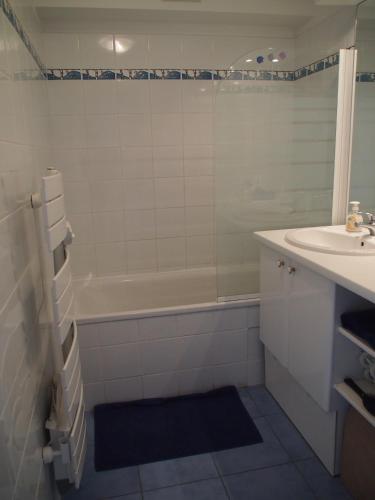 une salle de bain avec une baignoire et un lavabo et une baignoire dans l'établissement Entre dunes et mer, à Bray-Dunes