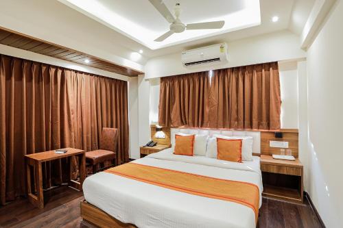 a hotel room with a bed and a desk at Hotel Ratna Mahal in Mumbai