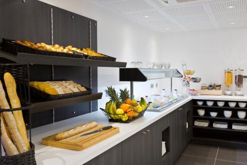 a kitchen with a counter with a bowl of fruit and bread at Simon's Boutique Hôtel in Paris