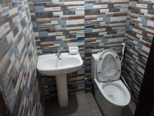 La salle de bains est pourvue de toilettes et d'un lavabo. dans l'établissement Adelle's Transient, spacious 3-bedroom homestay, à La Trinidad