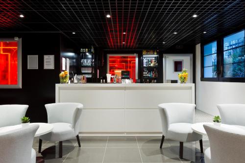 a restaurant with a bar with white chairs and a counter at Simon's Boutique Hôtel in Paris