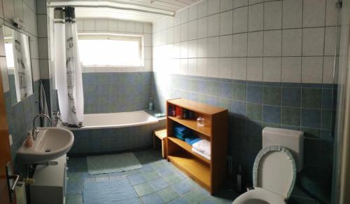 ein Badezimmer mit einer Badewanne, einem WC und einem Waschbecken in der Unterkunft Pension Wiesental in Wiesental