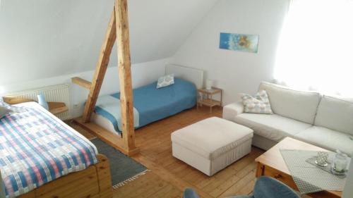 uma sala de estar com uma cama azul e um sofá em Pension Wiesental em Wiesental