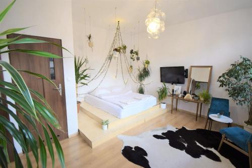 een slaapkamer met een bed in een kamer met planten bij Apartament na modrzejowskiej pełen sztuki i zieleni in Sosnowiec