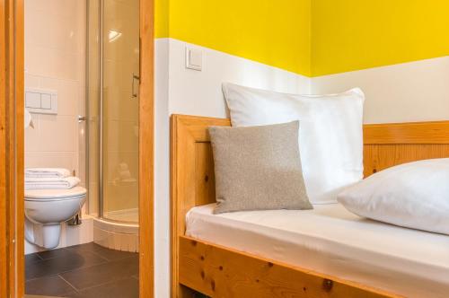 a bedroom with a bed with a shower and a toilet at Centro Hotel Sautter in Stuttgart