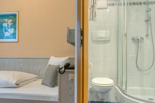 a small bathroom with a shower and a toilet at Sautter Hotel Stuttgart City in Stuttgart