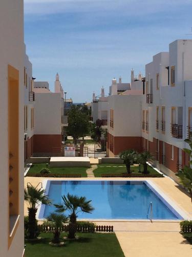 uma vista a partir da varanda de um edifício com piscina em Cabanas Pool Apartment em Cabanas de Tavira