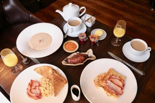 a table topped with plates of breakfast foods and coffee at Edinbane Lodge in Edinbane