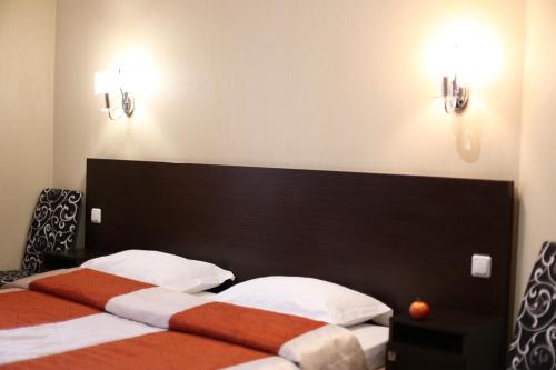 Okhtyrka的住宿－Готель "Палац"，一间卧室配有两张床,墙上有两盏灯