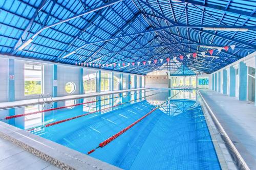 a large indoor swimming pool with a large ceiling at Hotel Star Dadaj Resort & Spa in Dadaj