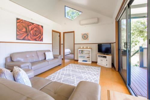 a living room with a couch and a tv at Chalet on Percheron in Margaret River Town