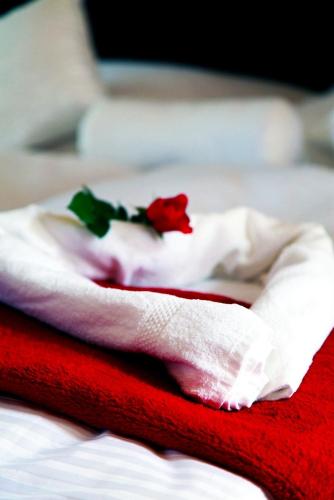 a red and white towel with flowers on a bed at Villa Rozmaryn & Gourmet in Mariánské Lázně