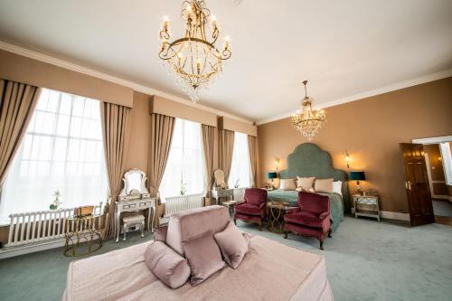 a large bedroom with a bed and a chandelier at Hawkstone Hall Hotel & Gardens in Shrewsbury