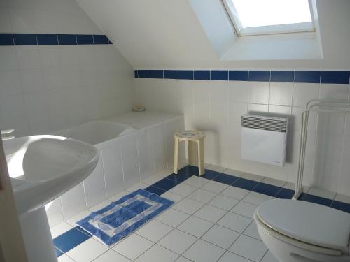 a bathroom with a tub and a toilet and a sink at Gîte du pré de la dame in Férel